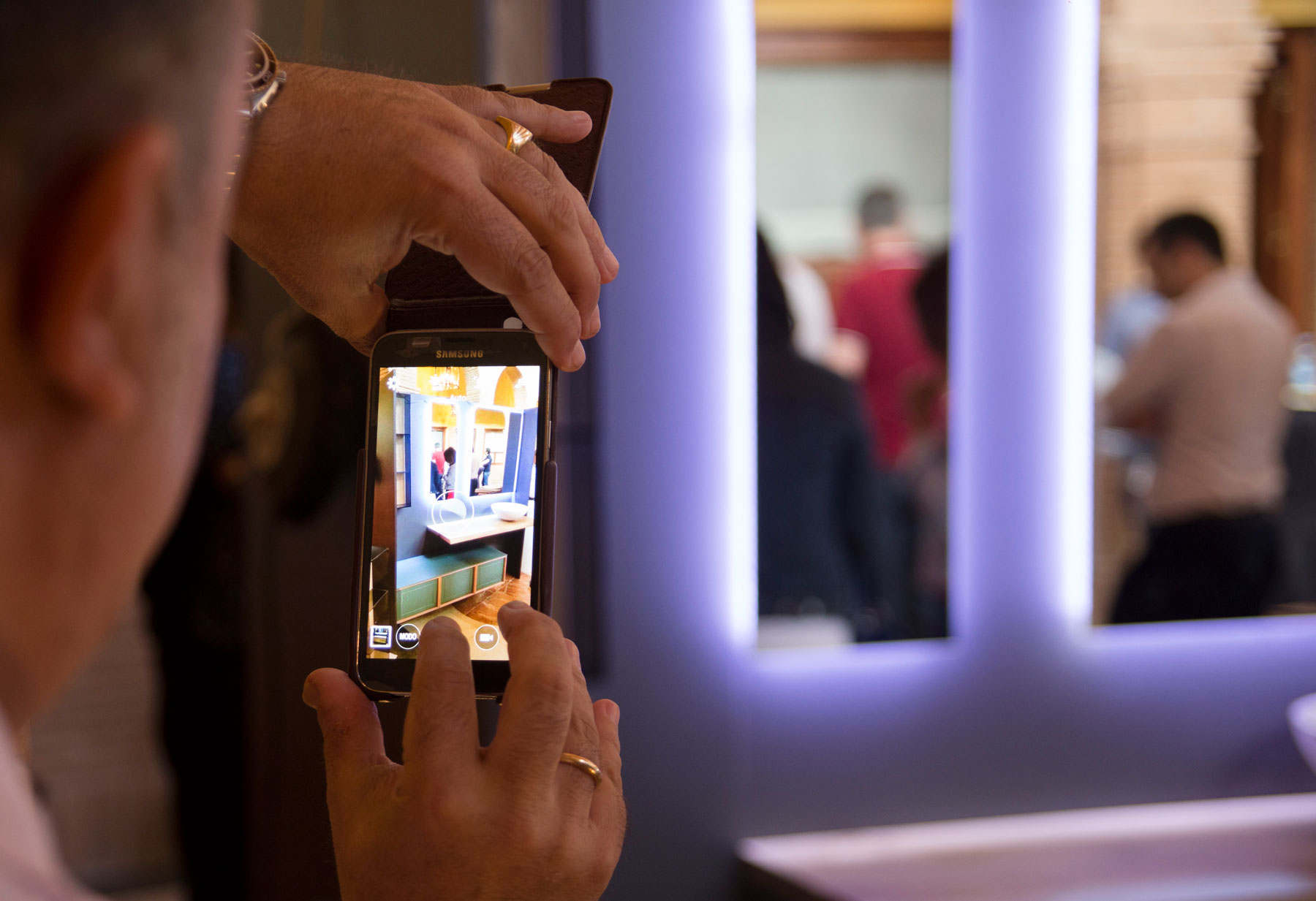 Hombre fotografiando la exposición con las nuevas piezas más importantes del catálogo de Delgado Bath en Bodegas Vivanco en Briones (La Rioja). Reportaje de Andrea Aragón