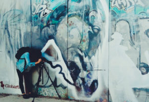 Fotógrafa junto a uno de los murales del proyecto 'La Calle es un Museo'. Reportaje de Andrea Aragón.